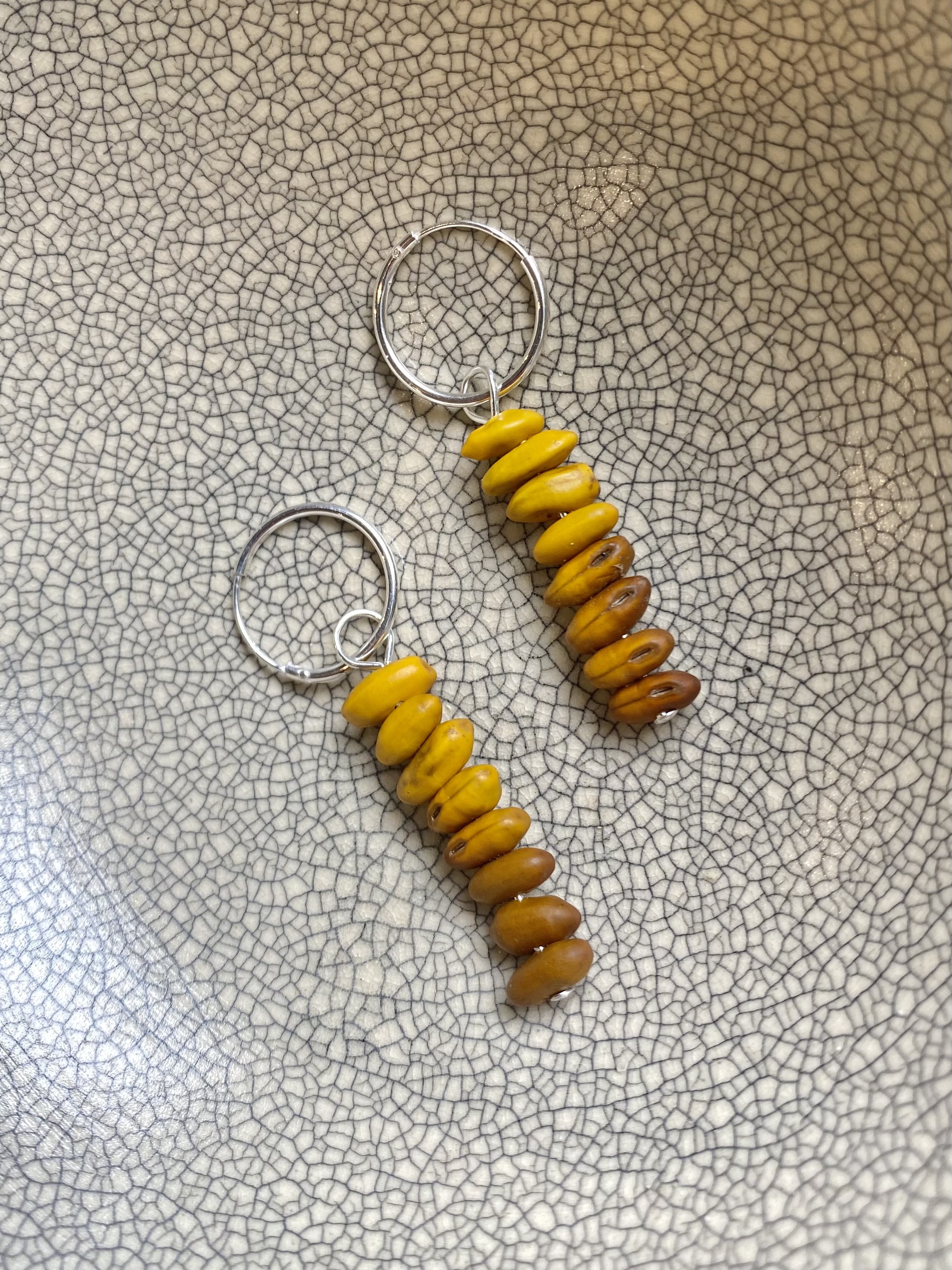Silver sleeper earings with kowhai tree inspired beads dropping from the sleeper